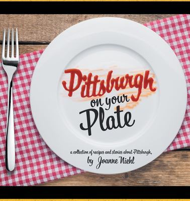 Table with fork and white plate on red checkered napkin with the title of the book in red and black on the plate