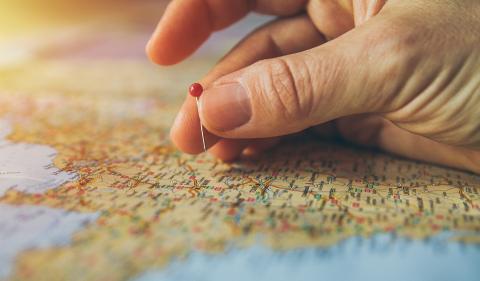 Hand pinning a spot on a map