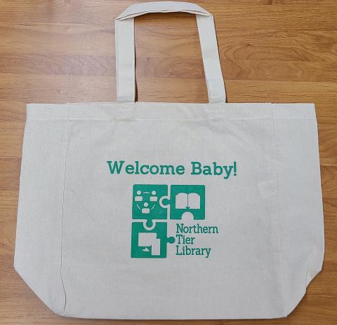 Welcome Baby! cream colored bag with green lettering and NTRL logo