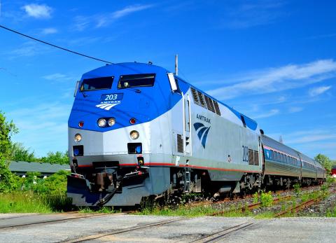 Amtrak train on the track with a blue sky background