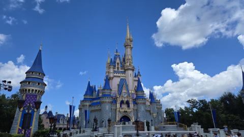 Clouds in a blue sky with Cinderella's castle in the center