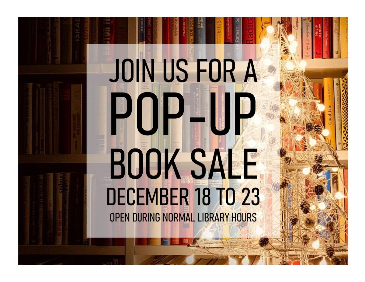 Book shelf in the background with a white light wooden Christmas tree with pinecone ornaments